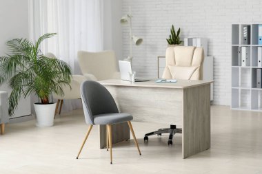 Doktorun çalışma yeri ve sandalyeleri olan bir muayenehane.