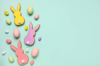 Turkuaz arka planda Paskalya yumurtalı tahta tavşanlar.