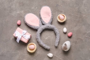 Paskalya yumurtalı tavşan kulakları ve grunge arka planında hediye kutusu.