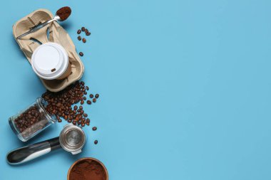 Kahve çekirdekleri, pudra ve mavi arka planda iskele filtresi olan paket kâğıdı bardağı.