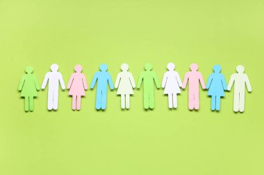 Yeşil arka planda renkli kağıt insan figürleri. Çeşitlilik ve kapsama kavramı