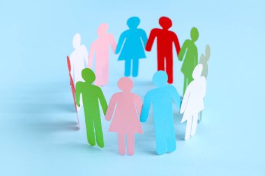 Kağıt insan figürleri renk arkaplanı üzerinde daireler çiziyor. Çeşitlilik ve kapsama kavramı