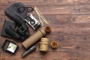 Şık termoslu, seyahat eşyalı, ahşap arka planda şapka ve çam kozalaklı kompozisyon