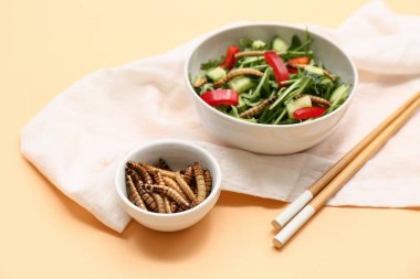 Taze salata ve turuncu arka planda kızarmış kurtçuk.