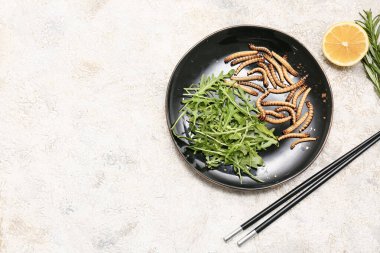 Beyaz arka planda roka ve limonlu kızarmış kurtçuk tabağı.