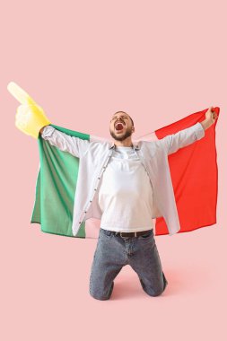 Pembe arka planda köpük el ve Meksika bayrağıyla çığlık atan spor hayranı.