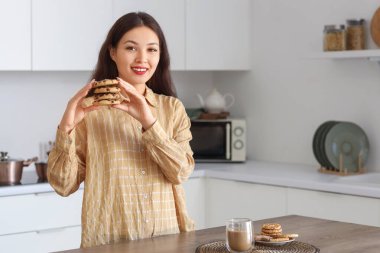 Mutfakta kurabiyeleri olan genç Asyalı kadın.