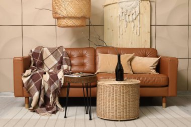 Rahat bir kanepe, kahve masası ve şişesi oturma odasının içinde.