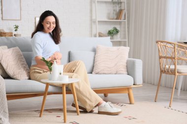 Evde cilt bakımlı genç hamile bir kadın var.