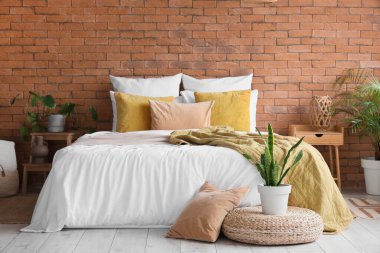 Duvarı tuğlalı modern yatak odasının içi.