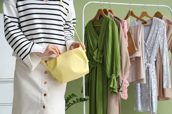 Soyunma odasında şık çantalı genç bir kadın.