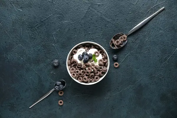 Mısır gevreği halkalı kase ve mavi grunge arka planda süt