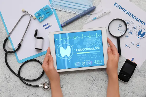 Elinde tablet bilgisayar ve tıbbi malzemeler olan bir kadın. Endokrinoloji kavramı