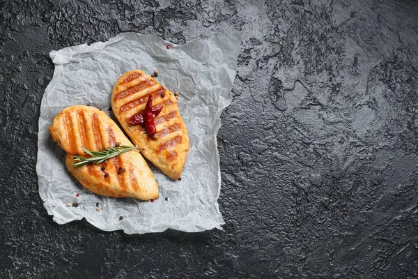 Lezzetli ızgara tavuk göğsü, biberiye, kurutulmuş kırmızı biber ve siyah grunge arka planda biber.