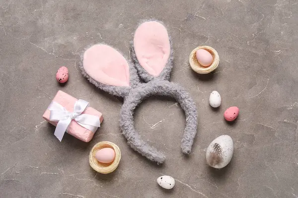 Paskalya yumurtalı tavşan kulakları ve grunge arka planında hediye kutusu.