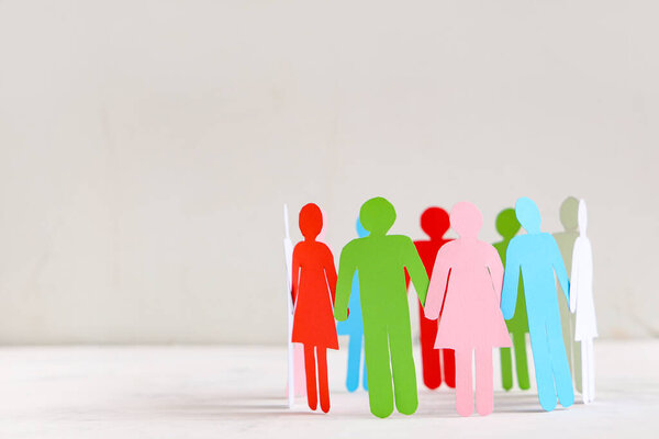 Бумажные человеческие фигуры образуют круг на светлом фоне. Концепция разнообразия и интеграции