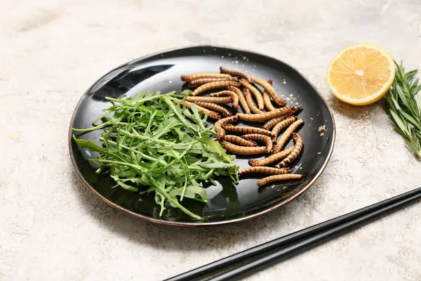 Beyaz arka planda roka ve limonlu kızarmış kurtçuk tabağı.