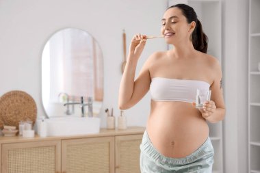 Hamile kadın banyoda diş fırçalama