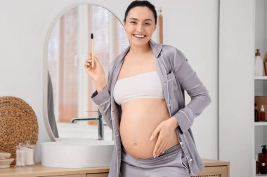 Hamile kadın banyoda diş fırçalama