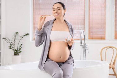 Hamile kadın banyoda diş fırçalama