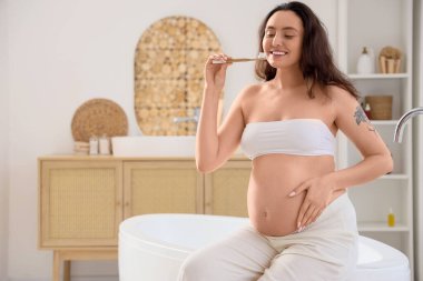 Hamile kadın banyoda diş fırçalama