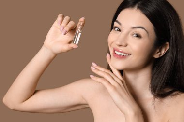 Kahverengi arka planda ampulü olan güzel bir genç kadın. Yakın plan.