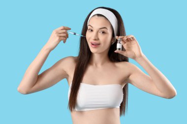 Mavi arka planda ampul ve şırıngası olan güzel genç bir kadın.