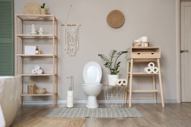 Tuvaletin içinde klozet, masa ve raf ünitesi var.