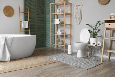 İçinde klozet, küvet ve raf ünitesi olan bir oda.