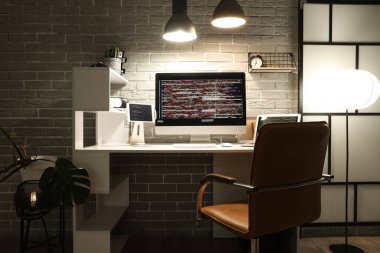 Programcının işyeri, gece ofiste cihazlar ve parlayan lambalarla.