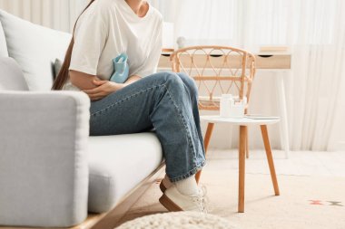 Evde adet sancısı çeken genç bir kadın.