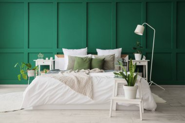 Yeşil duvarlı şık bir yatak odası.