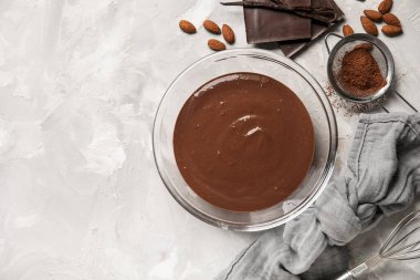 Bir kase sıcak çikolata, peçete ve kakao ile grunge grisi arka planda elek. Üst görünüm