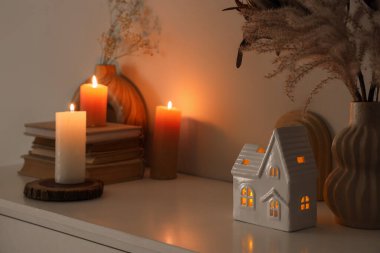 Evin şeklindeki mum tutacağı odadaki rafta, yakın plan