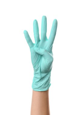 Tıbbi eldivenli kadın eli, beyaz arka planda dört parmak gösteriyor.