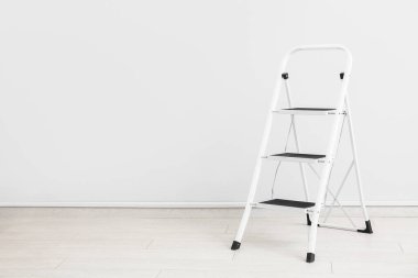 Bakım merdiveni beyaz duvarın yanında