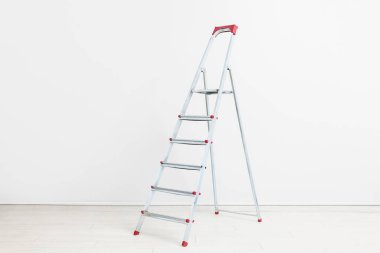 Bakım merdiveni beyaz duvarın yanında