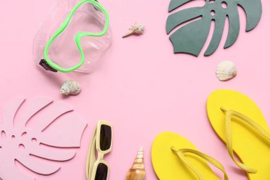 Tropikal kağıt yapraklardan yapılmış çerçeve, şnorkelle yüzen maske, parmak arası terlik ve pembe arka planda deniz kabuğu. Yaz konsepti