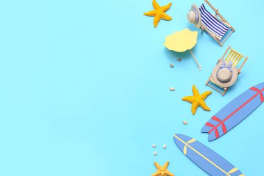 Güverte sandalyeli mini sörf tahtaları, deniz yıldızları ve mavi arka planda deniz kabukları. Yaz konsepti