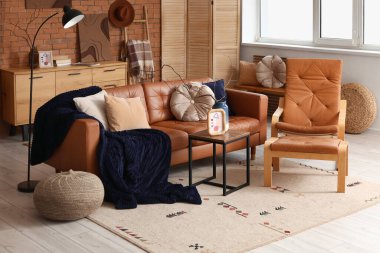 Oturma odasının içinde deri kanepe, koltuk, tuvalet ve sehpa var.