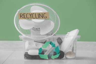 Yeşil duvarın yanında geri dönüşüm için elektronik atık içeren konteyner