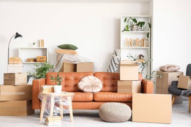 Taşındığı gün oturma odasında masa ve karton kutular olan kanepe