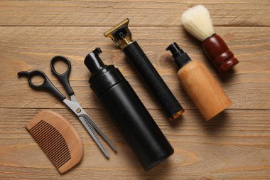 Ahşap arka planda modern budayıcı ve tıraş aksesuarları