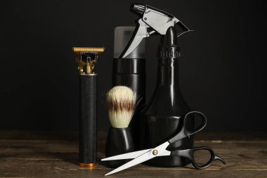 Makas, tıraş fırçası ve ahşap masada duran kozmetik ürünleri şişeleriyle modern budayıcı.