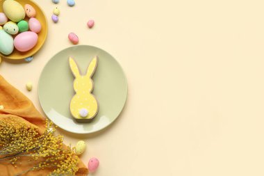 Tabaklarla, çiçeklerle ve bej arka planda Paskalya yumurtalarıyla kompozisyon