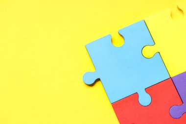 Sarı arka planda renkli yapboz parçaları. Otistik bozukluk kavramı