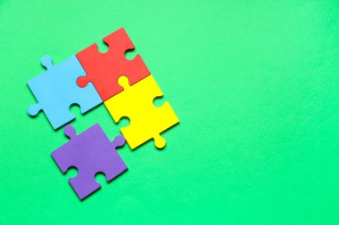 Yeşil arka planda renkli yapboz parçaları. Otistik bozukluk kavramı