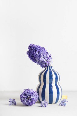 Beyaz arka planda güzel mor sümbül çiçekleri olan vazo