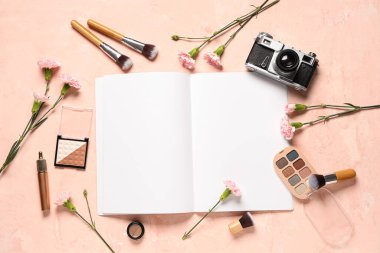 Çiçekler, kozmetik ürünleri ve pembe grunge arka planda fotoğraf makinesi olan boş moda dergisi. Bahar mevsimi konsepti
