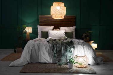 Şık bir yatak odası, rahat bir yatak odası, çiçekler ve geceleri parlayan lambalar.